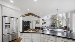 A modern kitchen with stainless steel appliances, white cabinetry, and a central island. - NEW Luxury Saratoga Track Rental: 4 miles to track, Hot tub, Sunroom, 8 beds! (Saratoga Springs)
