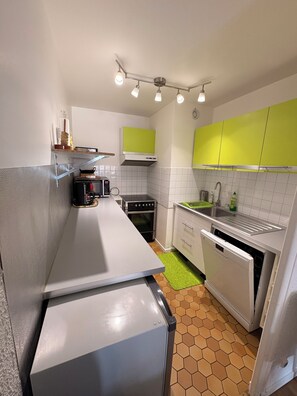 Eine kleine Küche mit Mikrowelle, Backofen und Geschirrspüler.