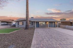 A residential house with a paved driveway, a lawn, and a palm tree. - Family Fun Getaway Near ASU & Phoenix Zoo (Tempe)