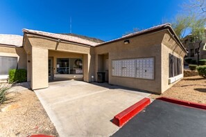 A building with a covered entrance, a parking area, and a mailbox. - Modern 2BR Townhouse |Shared Pool, Gym, Spa & More (Phoenix)