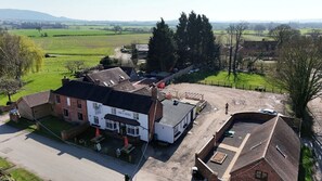 A building with a sign 'HOUND'S' and a fenced outdoor area. - The Winners Enclosure: Countryside Flat Above a Village Pub (Withington)