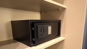 En förvaringsenhet med en svart frontpanel, en rund ratt och ett rutmönster på dörren.