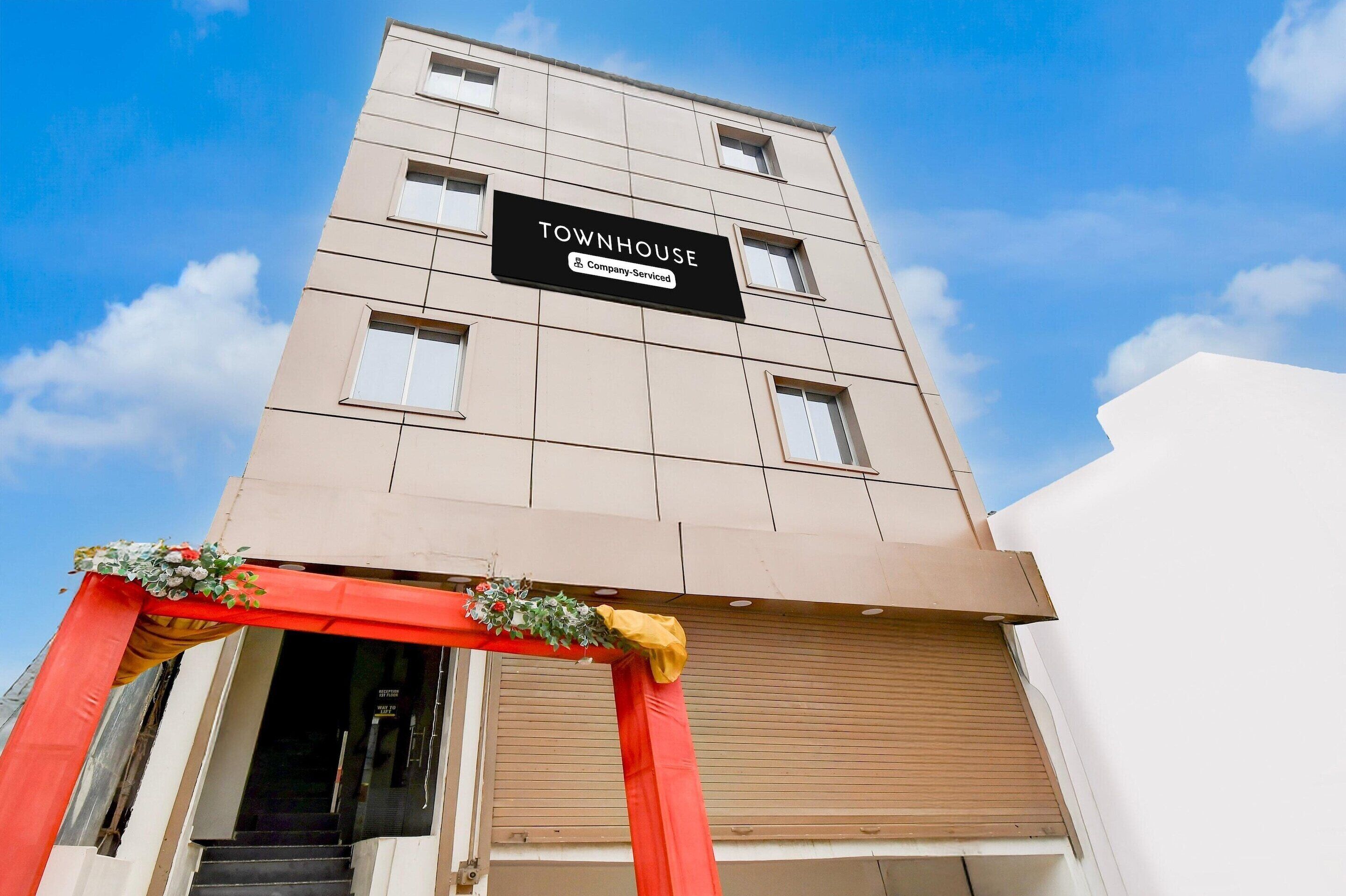 Ein Gebäude mit einem Schild, auf dem 'TOWNHOUSE' steht, und einem Firmenlogo.