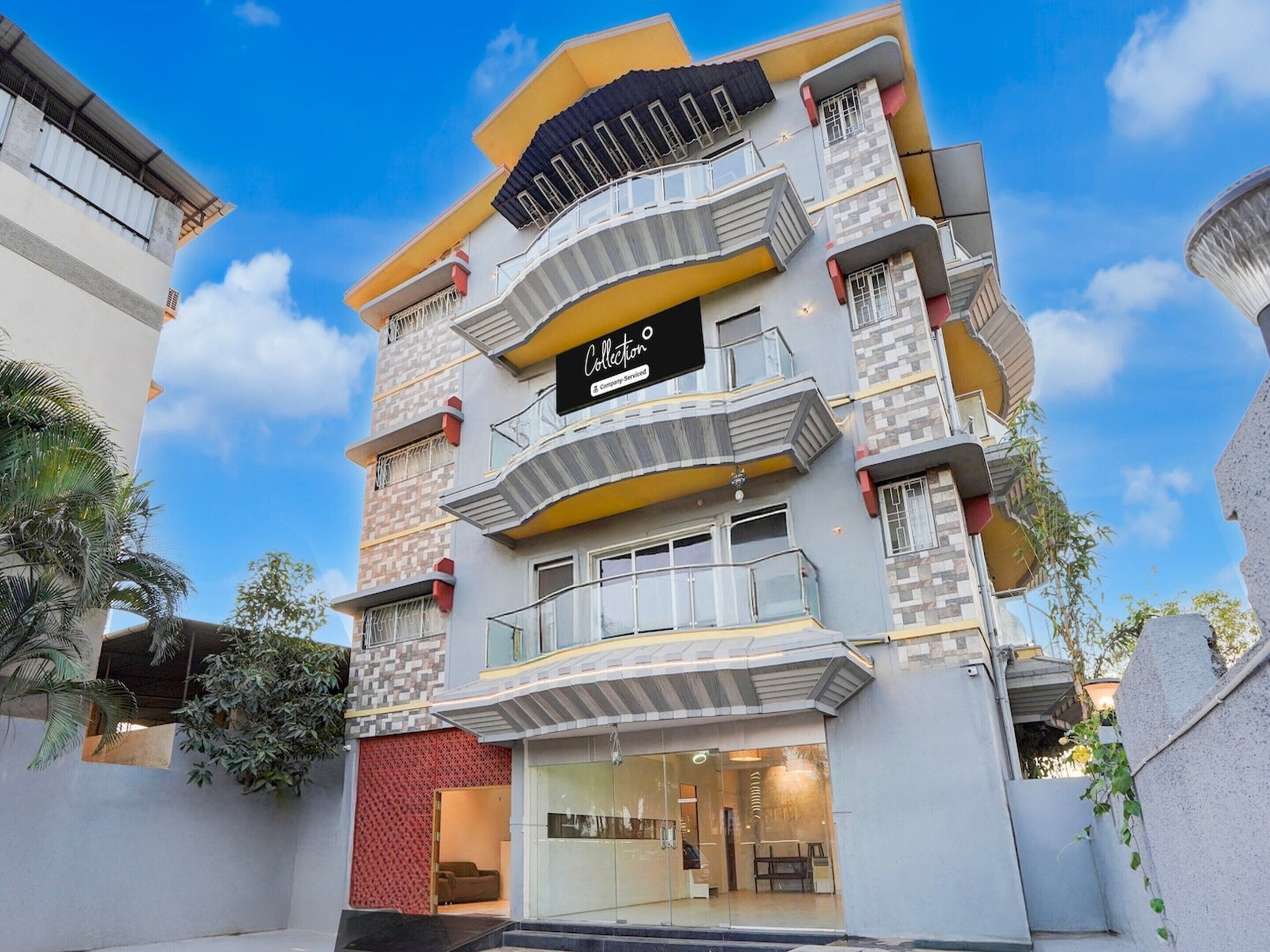 A multi-story building with balconies, a storefront, and a clear sky.