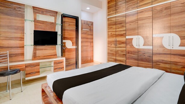 A bedroom with a bed, a desk, and a wardrobe. - Deluxe With Twin Bed Kaveri Executive Lodging (Rajgurunagar)