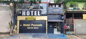 Entrada de hotel com uma placa indicando 'Hotel Pousada' e 'Toka do Skillo'.