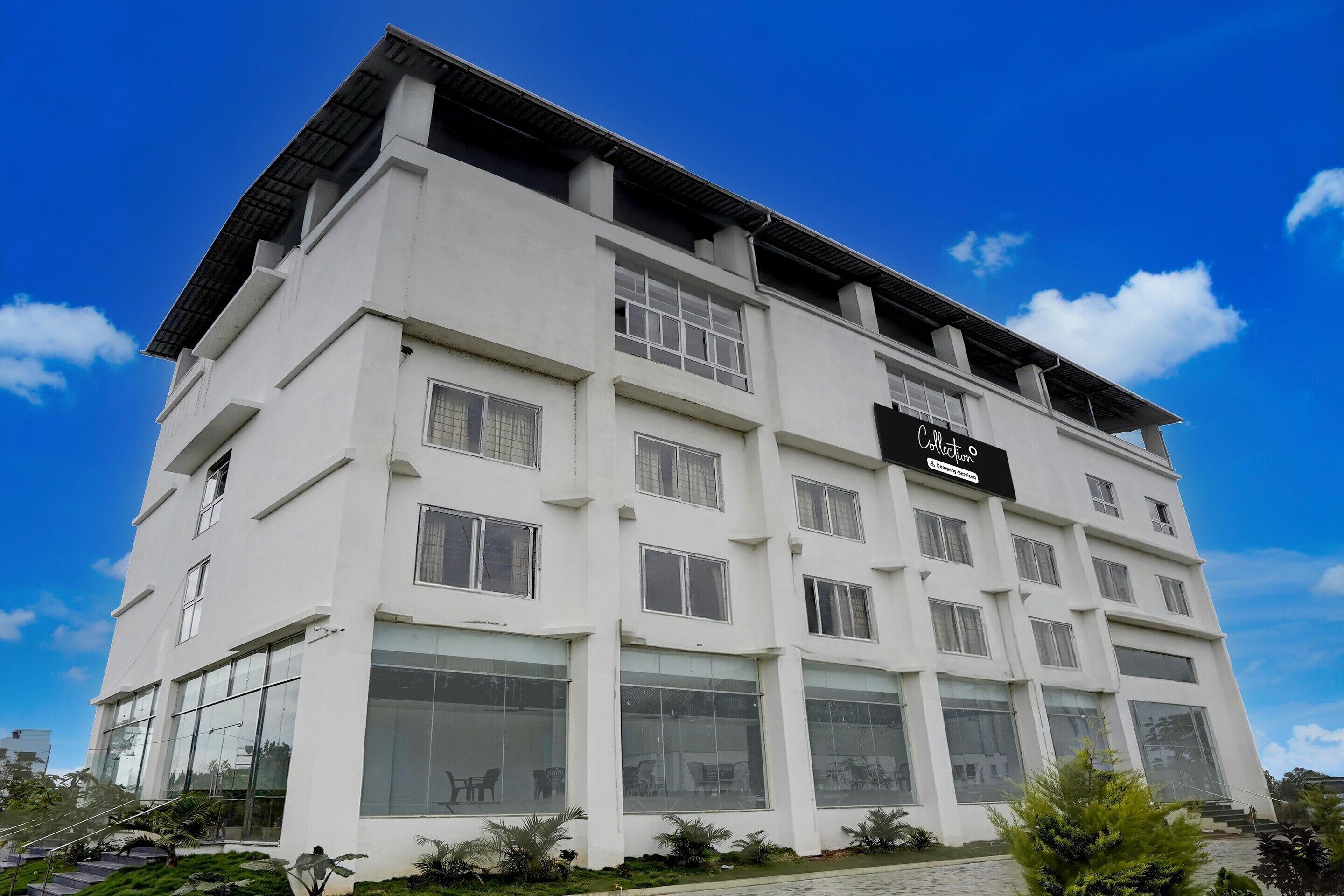 A multi-story hotel with large windows and a sign indicating it is a 'Cottage Hotel.'