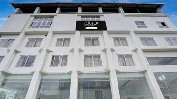 A multi-story building with a sign reading 'Collection & Company-Serviced.'