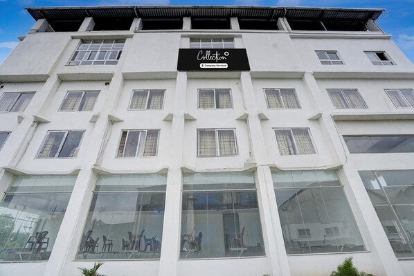 A multi-story building with a sign reading 'Collection & Company-Serviced.' - Deluxe Arasu Comforts (Hassan)