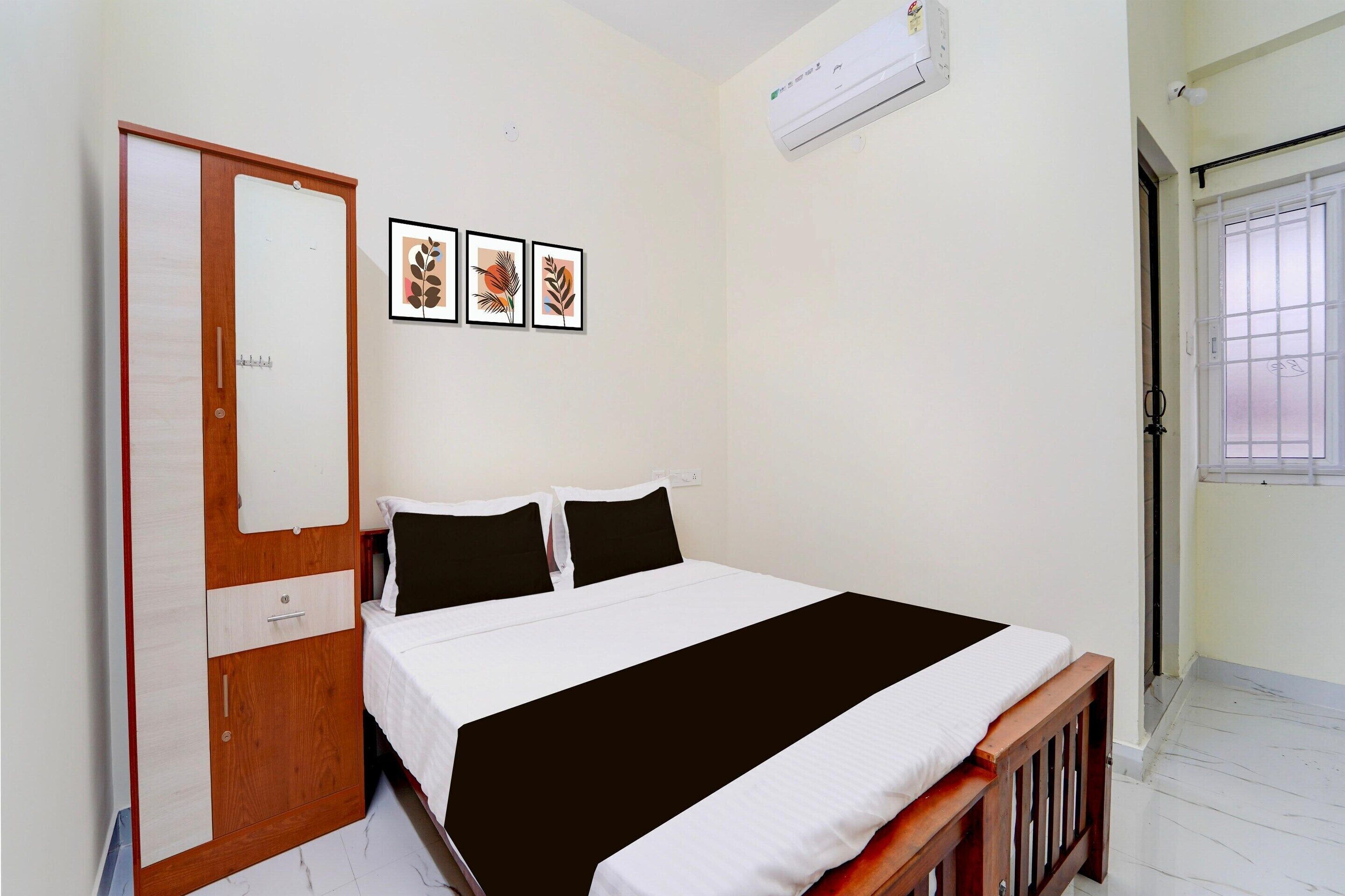 A bedroom with a bed, a wardrobe, a window, and wall-mounted artwork.