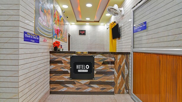 A hotel reception area with a check-in counter, a clock, and a sign indicating check-in time out. - Classic With Balcony Diamond Inn (Durgapur)