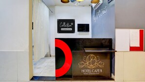 Una recepción de hotel con diseño moderno, un reloj digital y un letrero que indica 'Collection 9 Company-Serviced'.