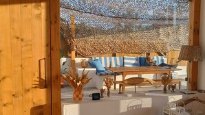 A wooden interior with a sofa, table, and decorative items. - Duck House (Comporta)