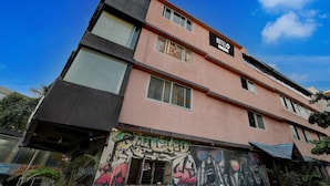 Un immeuble à plusieurs étages dont la façade porte une enseigne indiquant « HÔTEL ».