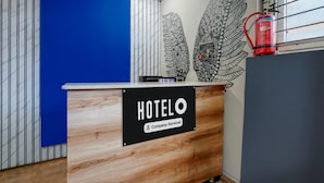 Un comptoir d’accueil d’hôtel avec un panneau indiquant qu’il est géré par l’entreprise.