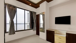 A room with a large window, a flat-screen TV, and a wooden ceiling. - Classic With Balconymahalunge Ingale Pune (Rajgurunagar)