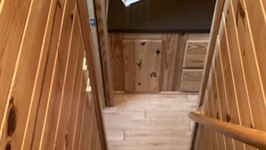 Un escalier en bois, dont les marches sont recouvertes de moquette, mène à une porte.