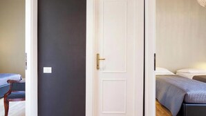 Ein Zimmer mit einem Bett, einem Stuhl und einer Tür.