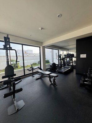 A gym with exercise equipment, large windows, and a view of the outside. - Modern 2-room apartment in Lince | Prime location (Lince)