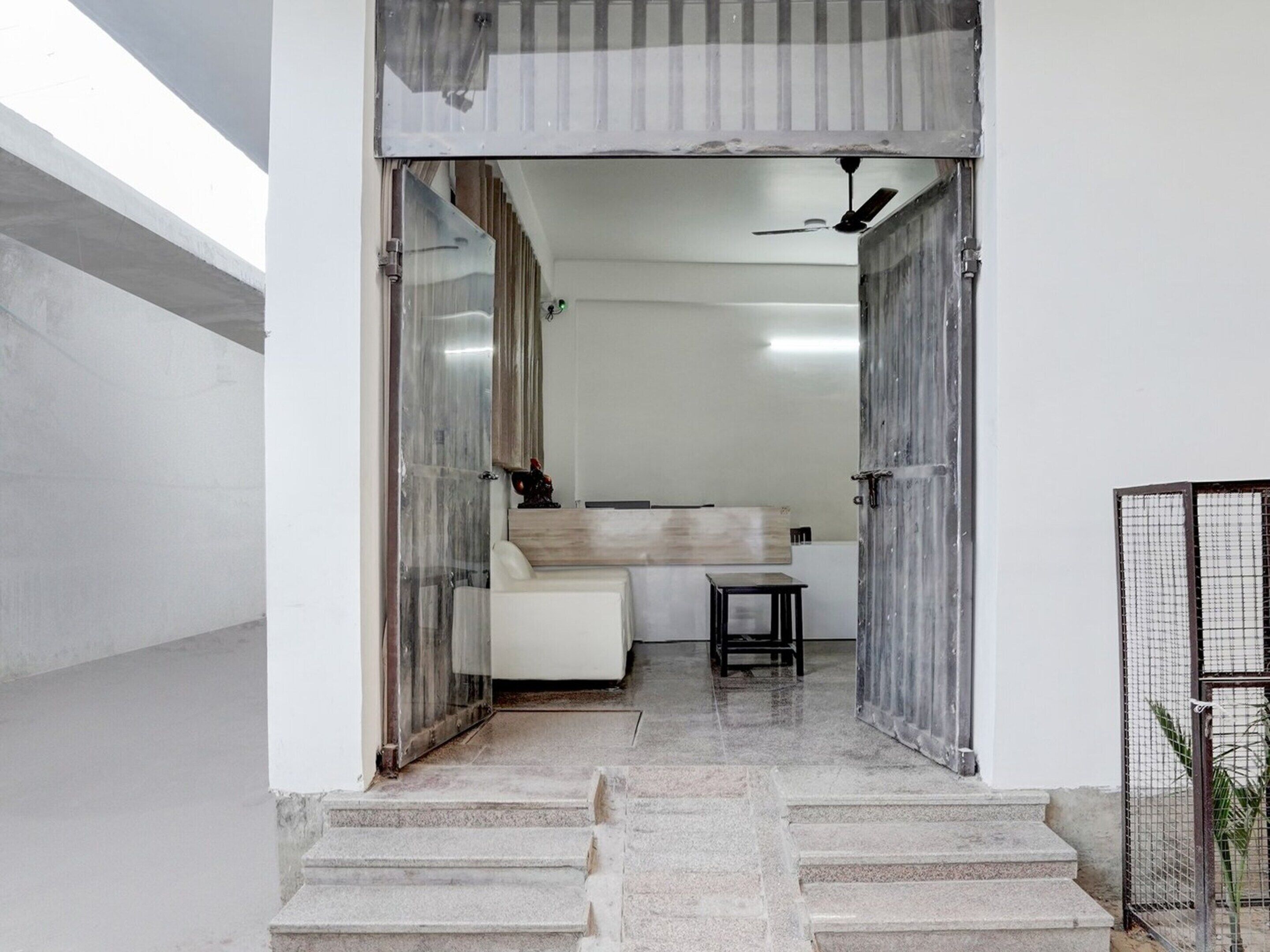 A modern interior with a staircase leading to a room with a bed and a small table.