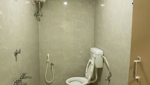 Egy kis fürdőszoba, amelyben WC, bidé és mosdókagyló található.