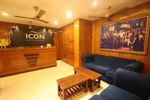 A reception area with a wooden reception desk, a blue sofa, and a framed historical photo.