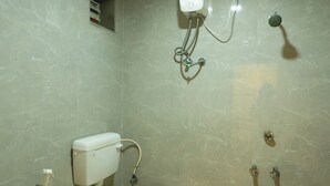Egy fürdőszoba, amelyben WC, bidé és zuhanyzó található.