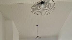 A living room with a white sofa, a coffee table, a TV, and a ceiling fan. - Quiet house near the ocean (Saint-Hilaire-de-Riez)