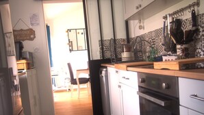 A kitchen with white cabinets, a wooden countertop, a dishwasher, and a stove. - Quiet house near the ocean (Saint-Hilaire-de-Riez)