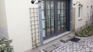 A house with a large window, a door, and a small garden area.