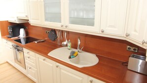 A kitchen with a sink, stove, and cabinets.