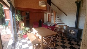 Una habitación acogedora con suelo a cuadros, muebles de madera, una escalera y un estufa de leña.