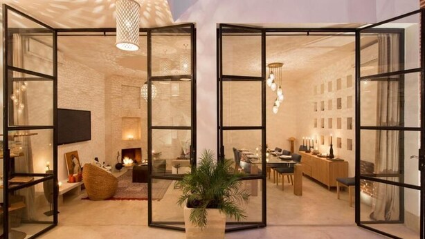 A modern interior with a fireplace, seating area, and a dining space. - Riad La source du Désert (Marrakech)