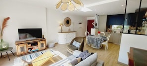 A modern living room with a television, sofa, and dining table. - Cosy apartment Port de la Trinité-sur-Mer (La Trinité-sur-Mer)
