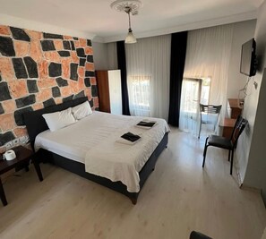 Ein Schlafzimmer mit Steinwand, einem Bett, einem Schreibtisch und einem Stuhl.