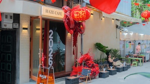 A cafe with a glass door, outdoor seating with chairs, and a sign indicating the cafe's name. - IL DIVO Hotel & Spa Hanoi Old Quarter (Hanoi)
