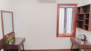A room with a wooden desk, a mirror, a window with decorative iron bars, and a built-in shelf. - IL DIVO Hotel & Spa Hanoi Old Quarter (Hanoi)