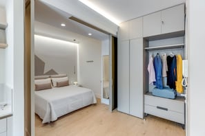 A modern bedroom with a bed, a walk-in closet, and a mirror. - A Cozy Stay with Terrace in the Heart of Sorrento (Sorrento)
