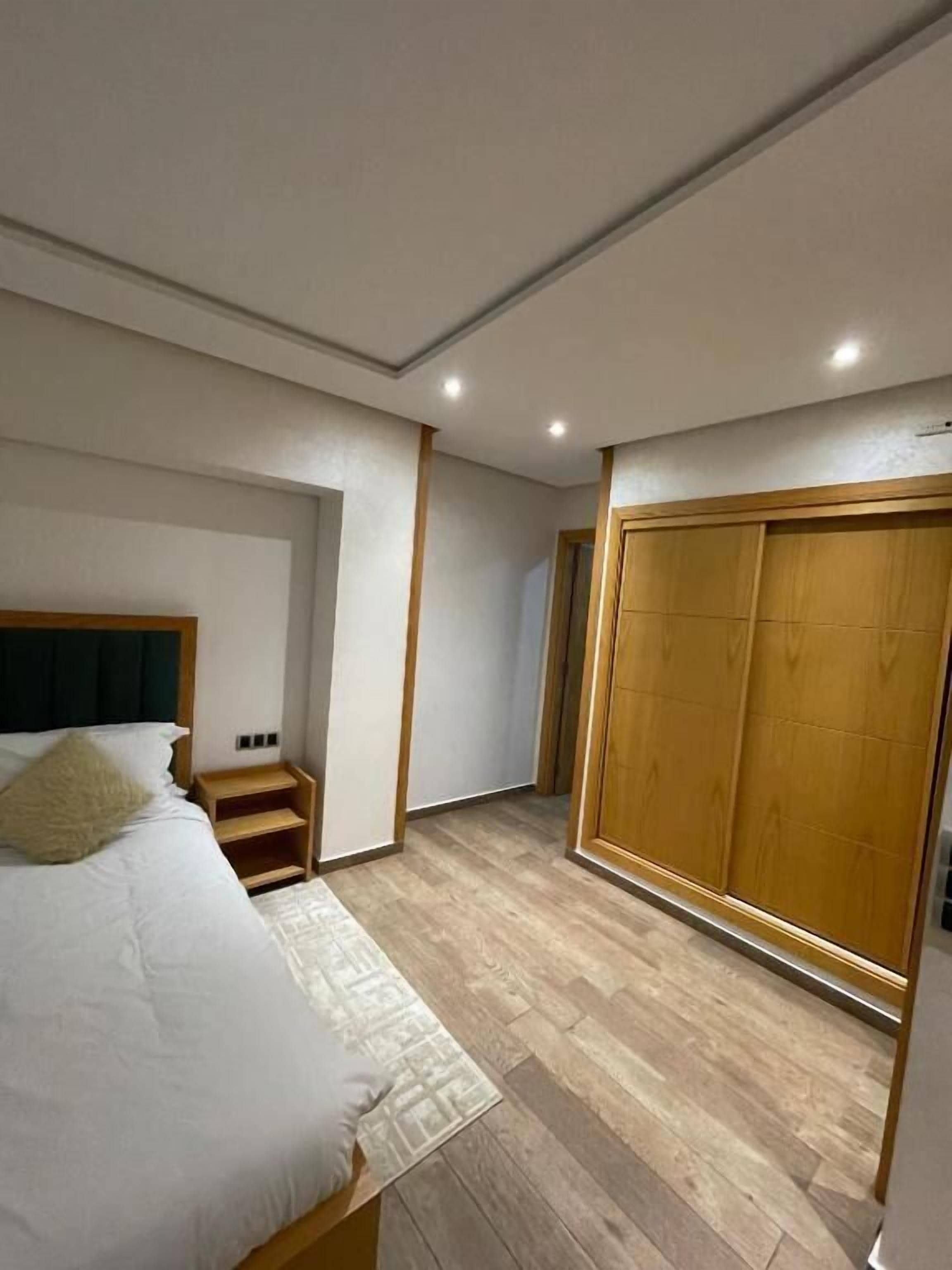 A bedroom with a bed, bedside table, and a wardrobe.