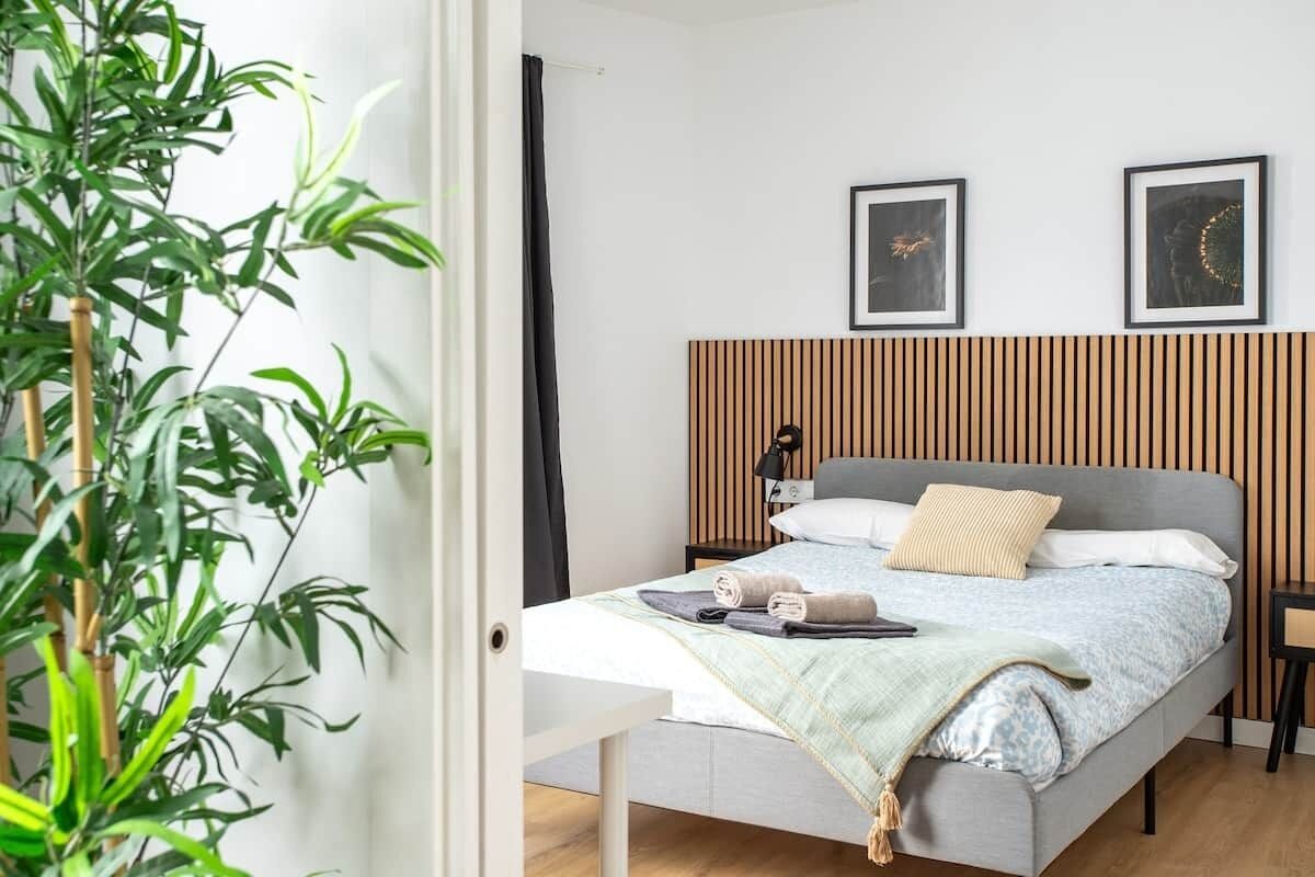 Une chambre à coucher avec un lit, des tables de chevet, une lampe et deux tableaux encadrés accrochés au mur.
