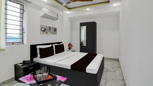 A hotel room with a bed, bedside table, nightstand, and a ceiling fan. - Classic With Balcony Mourigram Near Andul Road (Howrah)