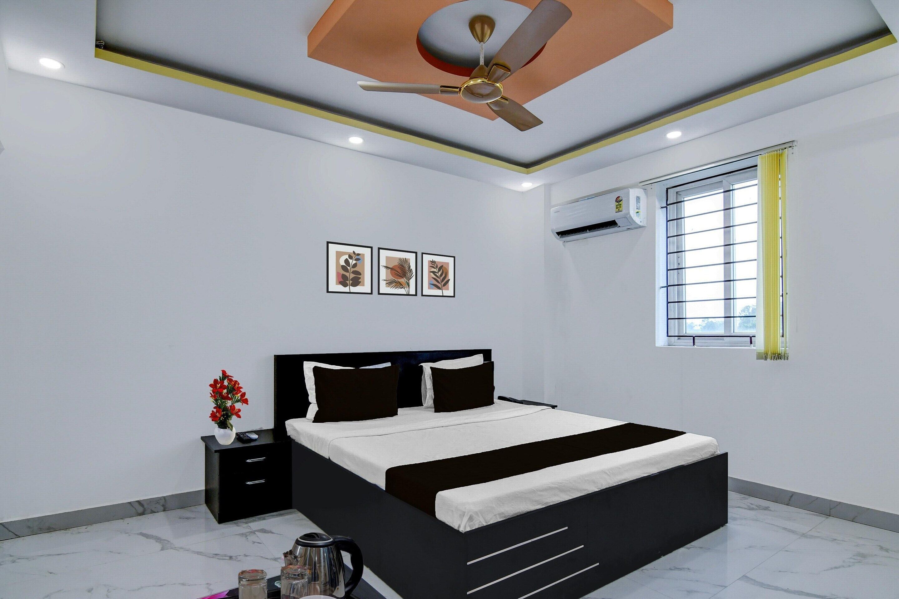 A modern bedroom with a bed, bedside tables, a ceiling fan, and a window with curtains.