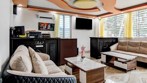 A modern living room with a sofa, a coffee table, a flat-screen TV, and a fireplace. - Classic With Balcony Mourigram Near Andul Road (Howrah)