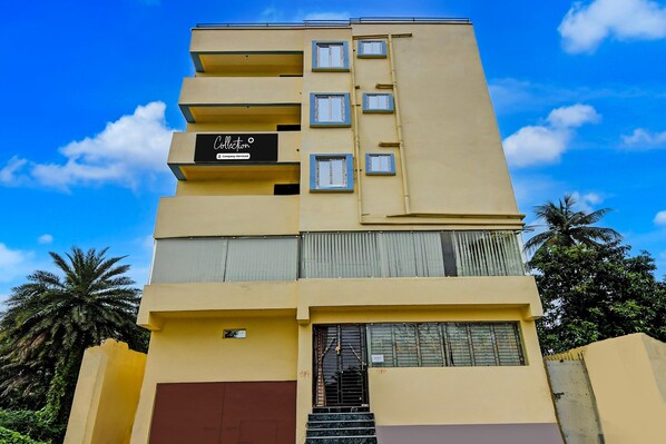 A multi-story building with balconies, a company service sign, and a staircase leading to the entrance. - Classic With Balcony Mourigram Near Andul Road (Howrah)