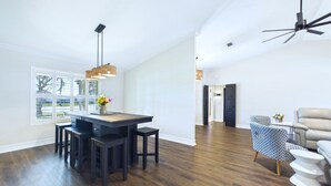 A spacious room with a dining area, a ceiling fan, and a view of the outdoors. - Indian Harbor Beach Pool Retreat (Indian Harbour Beach)