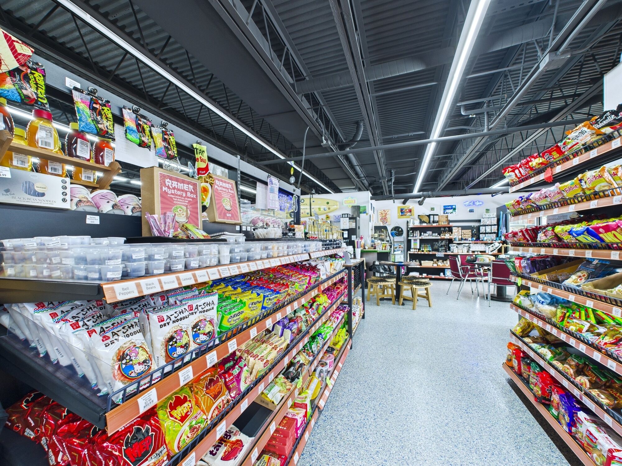 Ein Gang in einem Supermarkt mit verschiedenen verpackten Lebensmitteln und Getränken.