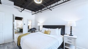 Una moderna camera d'albergo con un letto grande, comodini e una ventola a soffitto.