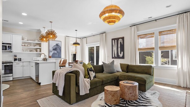 Ein modernes Wohnzimmer mit einem grünen Sofa, Holznachttischen und einem Teppich mit Zebra-Muster.
