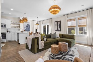 A modern living room with a green sofa, wooden side tables, and a zebra-patterned rug. - Downtown Wilmington | Walk to Riverwalk & Live Oak (Wilmington)