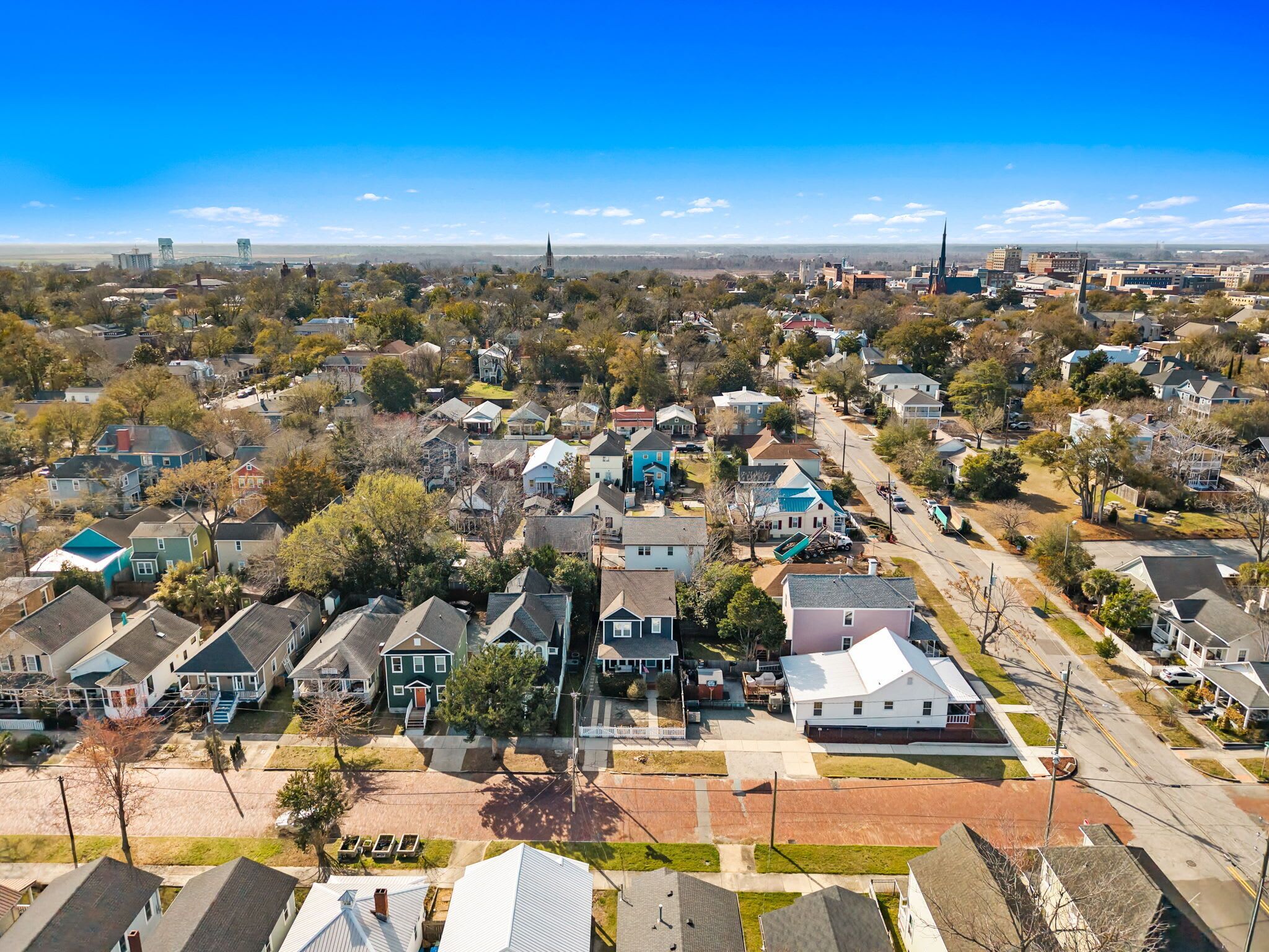 Luchtbeeld van een woongebied met huizen, straten en een verafgelegen kerktoren.